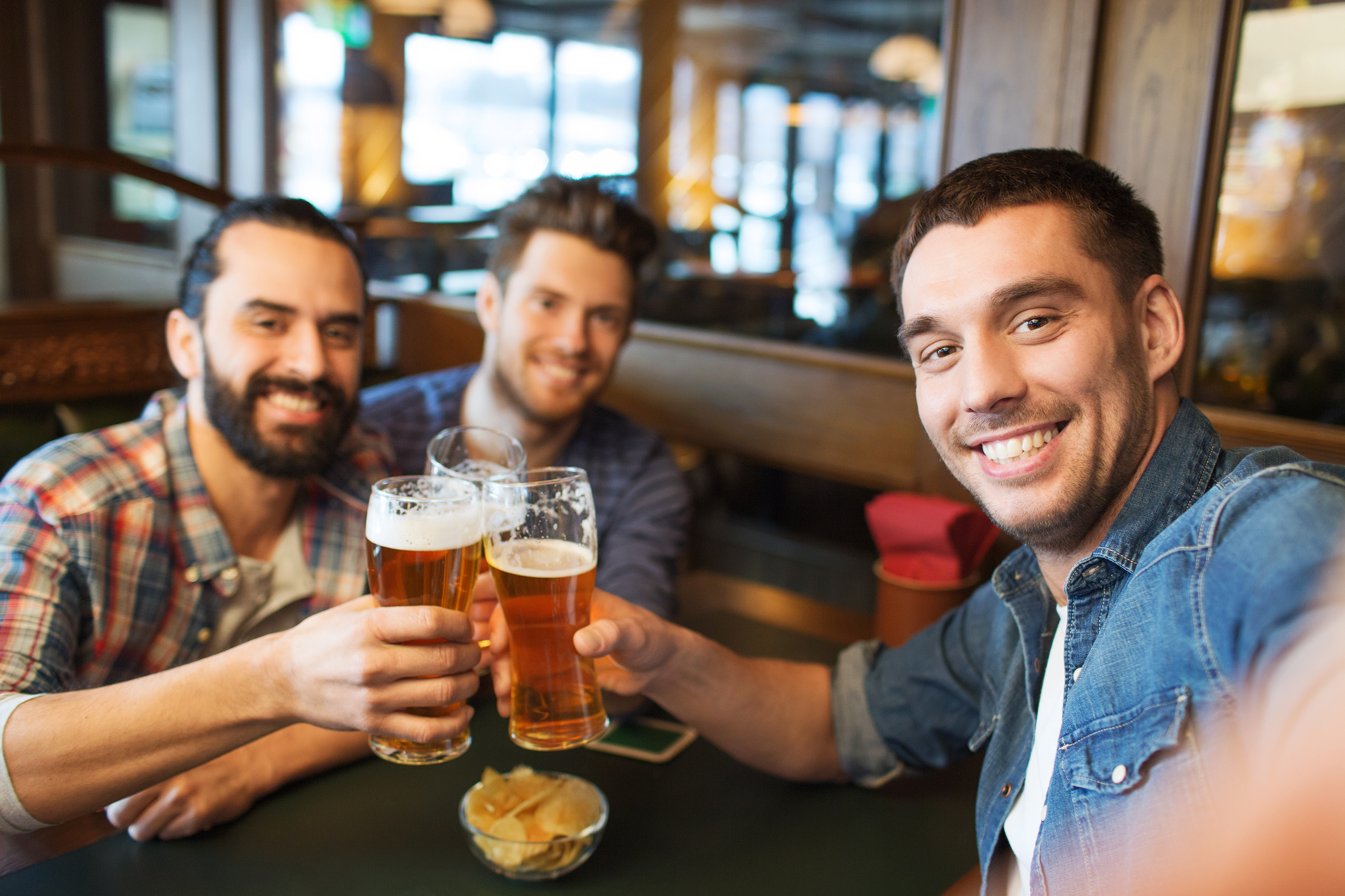 friends taking selfie and drinking beer at bar – ETInside